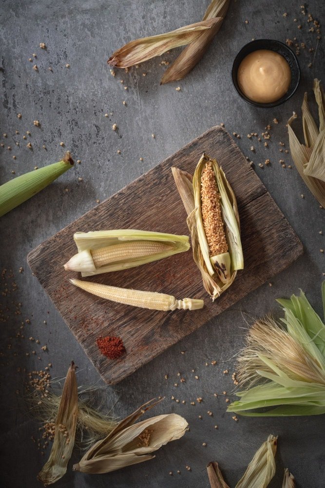food photographers Singapore  there are many corns placed on the chopping board