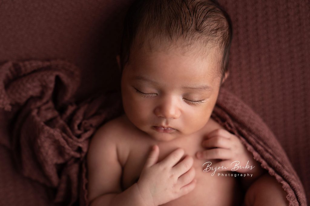 newborn photography Sydney baby is sleeping around a brown blanket