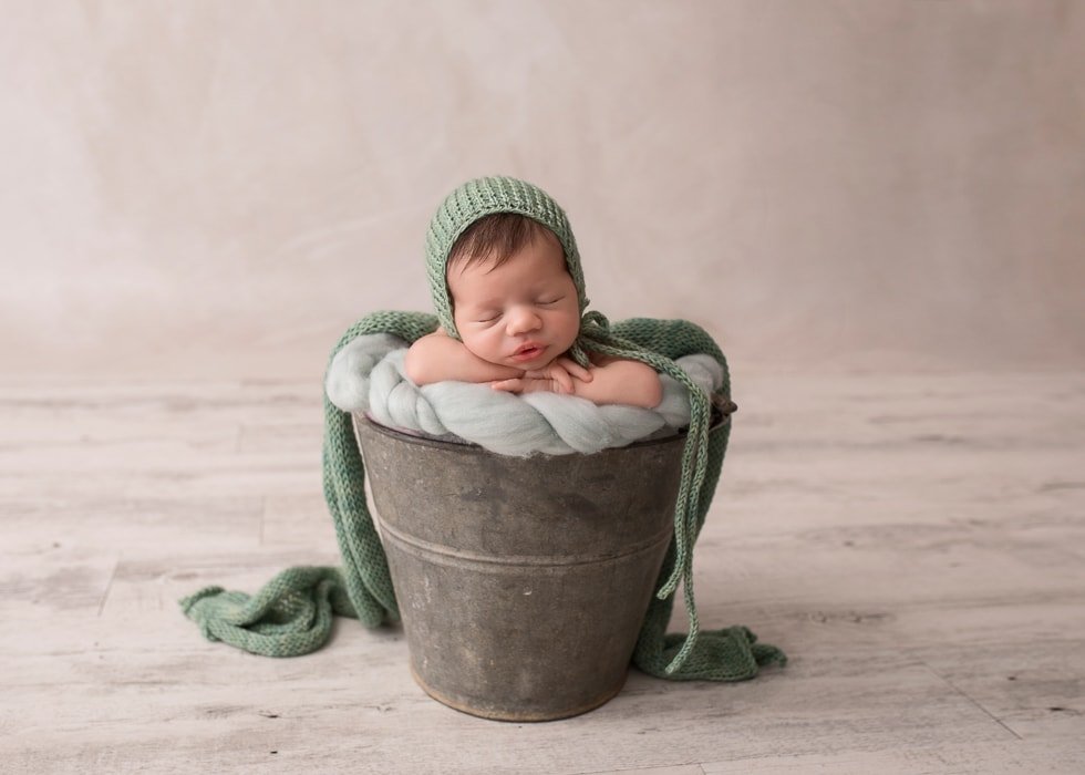 photography for newborns Sydney baby is sleeping in a bucket 