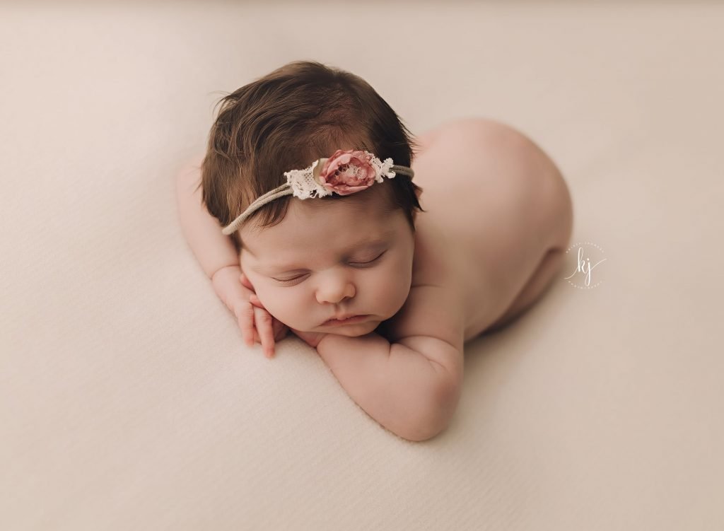newborn photography Sydney baby is sleeping with a flower headband
