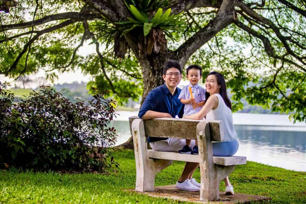 photoshoot for family parents and kid sitting on a bench and smiling