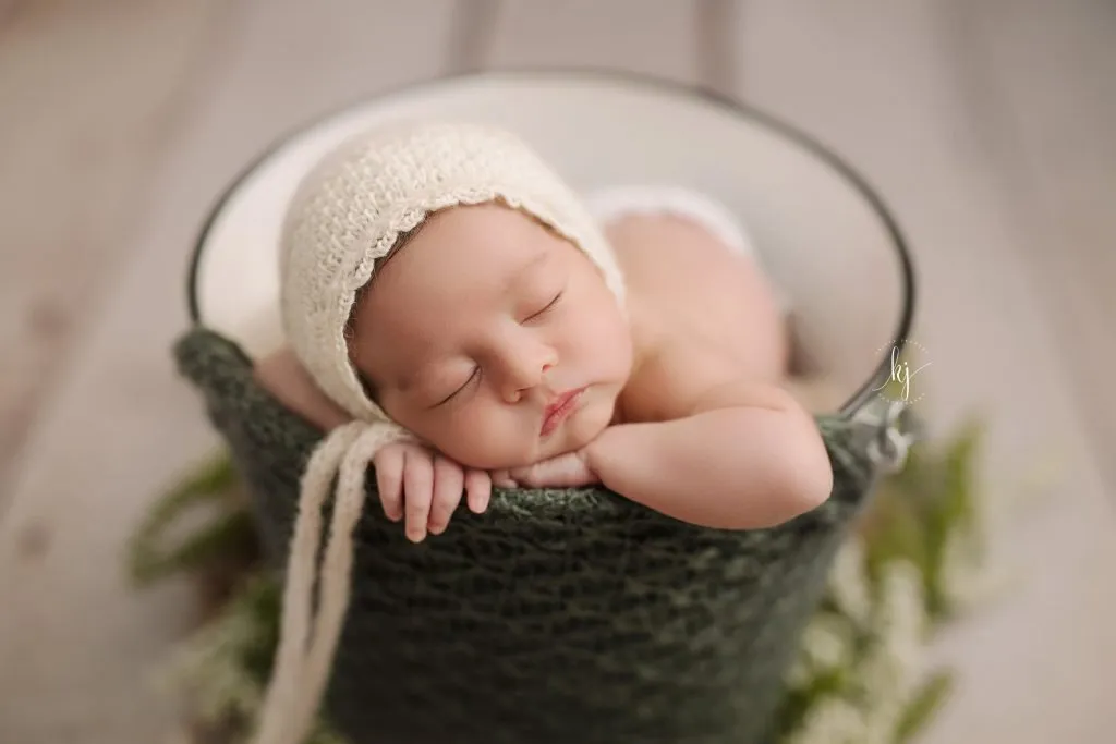 Sydney newborn photography baby is sleeping in a green basket