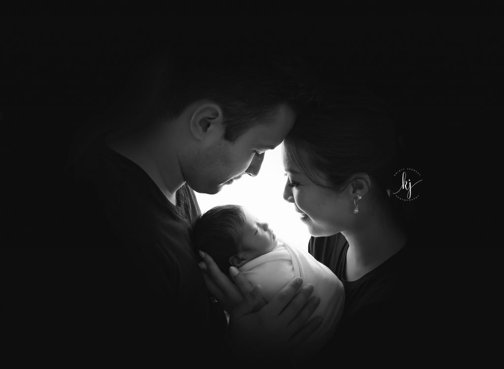 newborn photographer Sydney parents are admiring their baby in a black and white photo