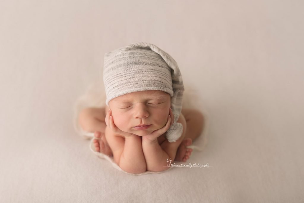 Sydney newborn photography baby is sleeping with arms on the cheeks