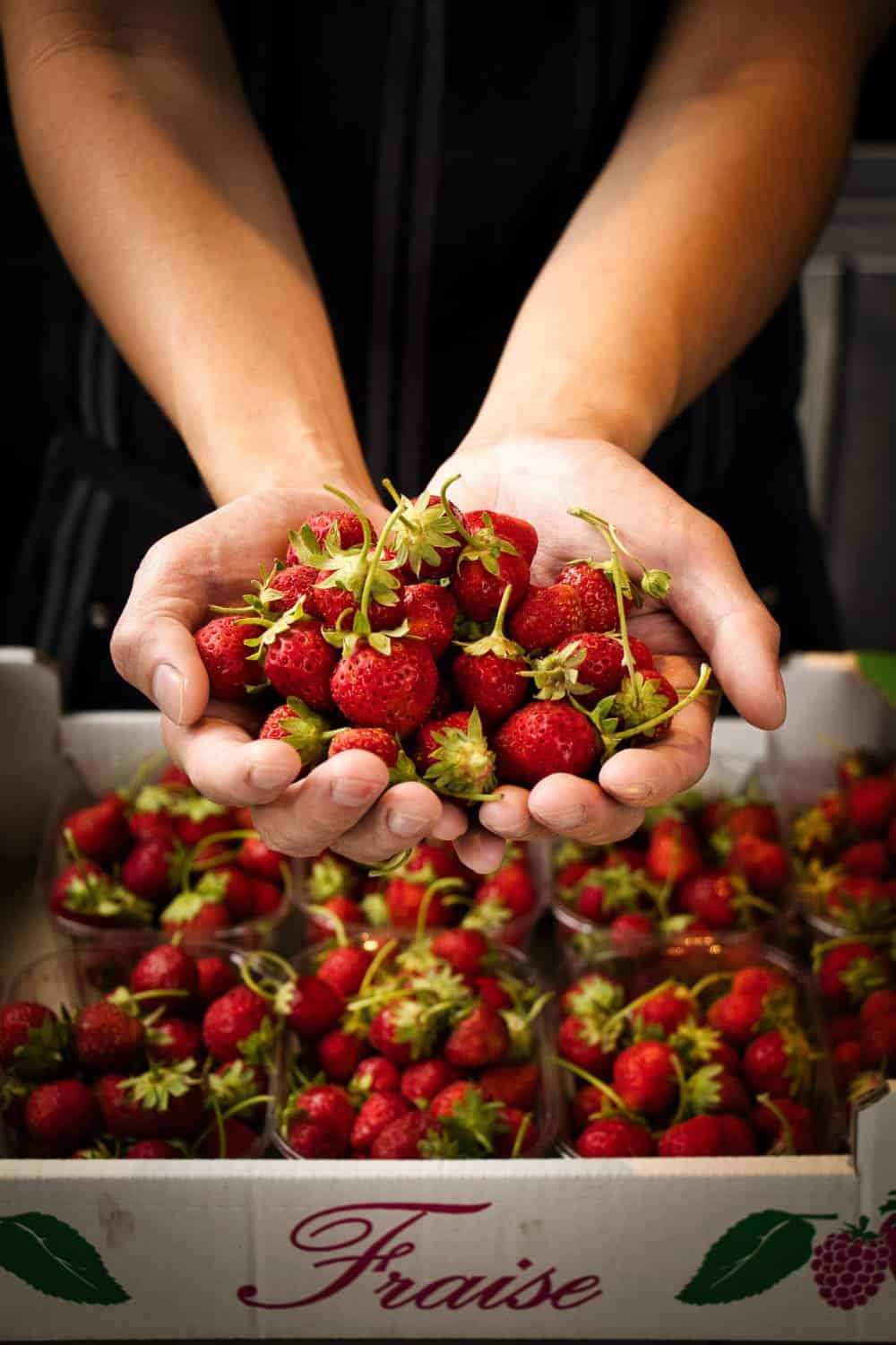 food photography Singapore a person has scooped out a handful of fresh strawberries