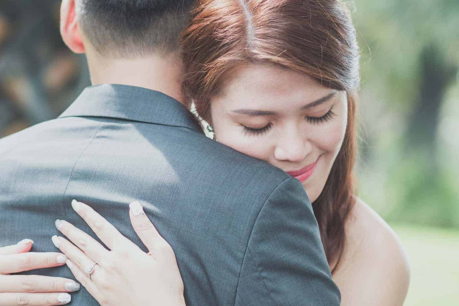 wedding photographers singapore a woman hugging her husband lovingly