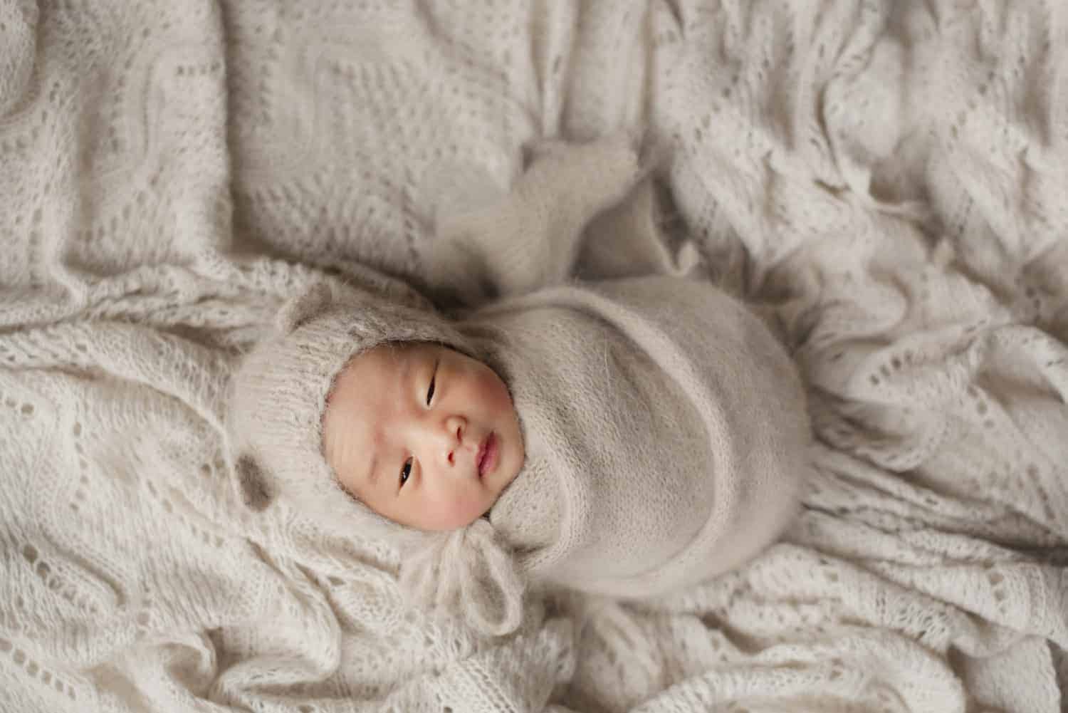 baby photoshoot singapore newborn curled up in a blanket