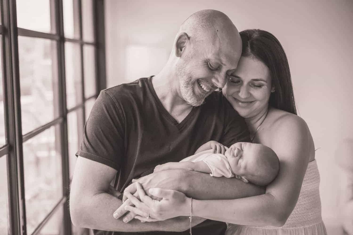 newborn photography singapore parents looking at baby and smiling