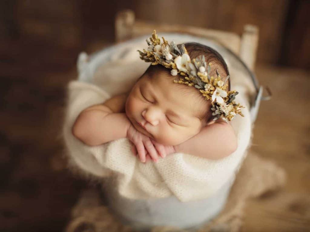 baby photographers Londonnewborn with neutral tone head crown is sleeping in a white basket