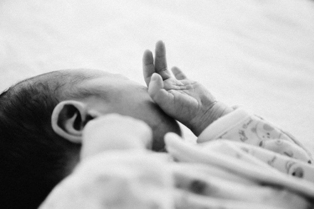newborn photography London side angled black and white photo of the baby sleeping