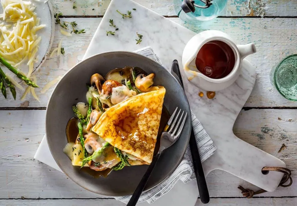 A plate of food on a table next to a cup of coffee captured by food photographers in Toronto.