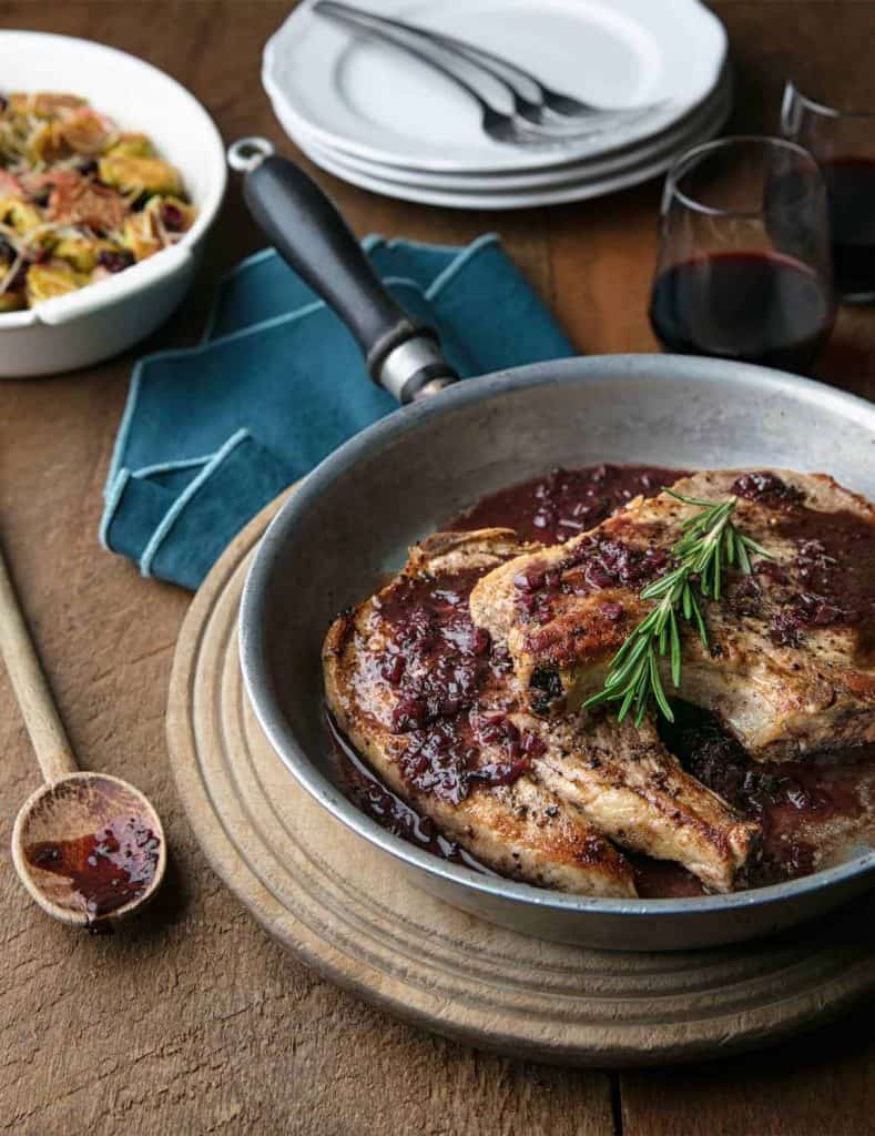 Chicken with cranberry sauce on a wooden table.