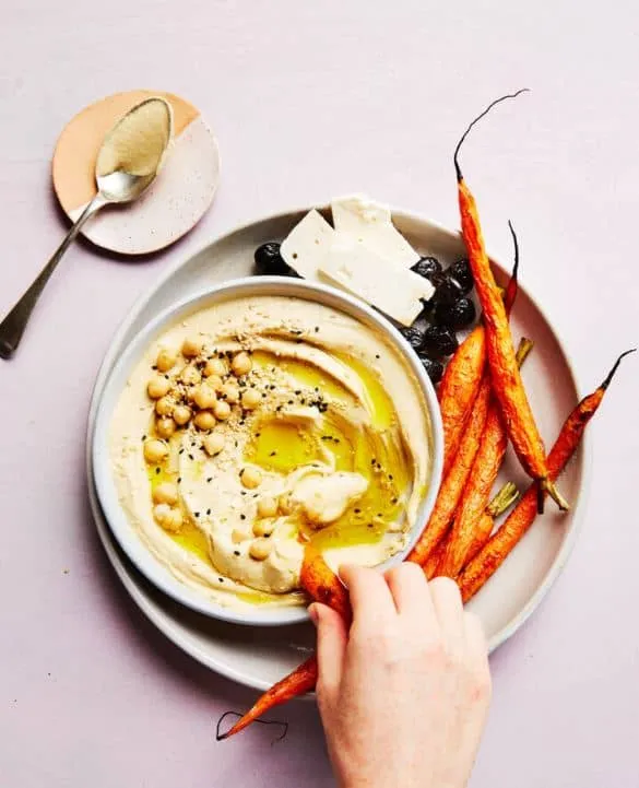 A plate of hummus and carrots presented by food photographers in Toronto.