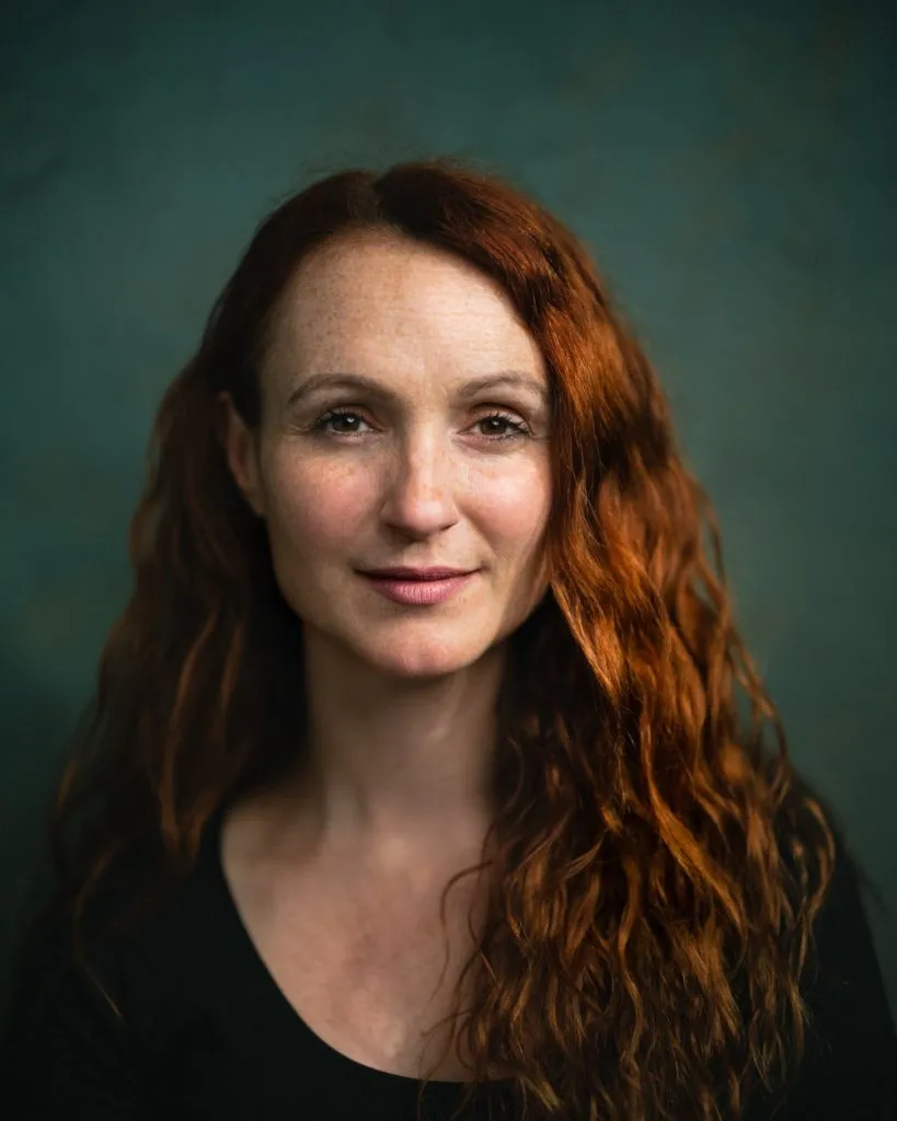 A portrait of a woman with red hair.
